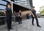 Police officers stand guard a building where the Japanese embassy is located in Seoul.