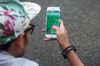 A man plays Nintendo Co.'s Pokemon Go augmented-reality game, developed by Niantic Inc., on their smartphones at Yoyogi Park in Tokyo, Japan, on Sunday, July 24, 2016. Nintendo shares plunged by the most since 1990 after the company said late Friday that the financial impact from the worldwide hit Pokemon Go will be limited.