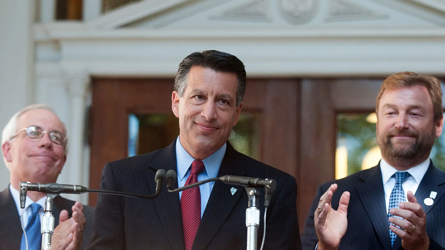 Brian Sandoval, governor of Nevada, center, is applauded during a news conference at the Nevada State Capitol building in Carson City on Sept. 4, 2014.
