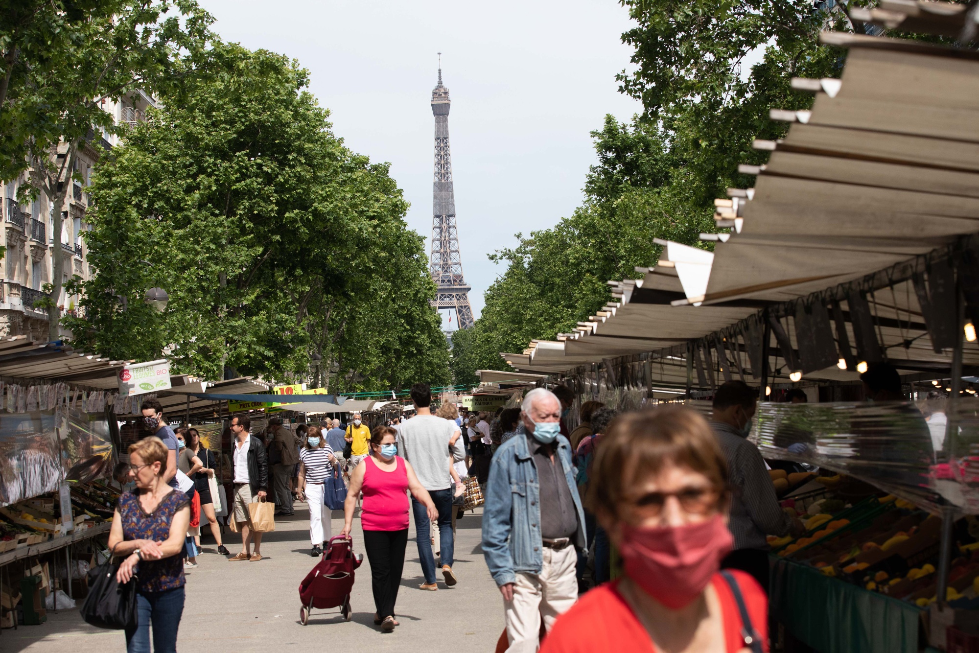 Shoppers pass fruit and vegetable market stalls near the Eiffel Tower on May 21.