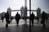 Pedestrians are seen walking through the More London office space against the backdrop of Tower Bridge in London, U.K., on Wednesday, April 24, 2013. The pound rose for a third day against the euro before an industry report that economists said will show U.K. retail sales increased and amid speculation the Bank of England's loan-program extension will boost the economy.