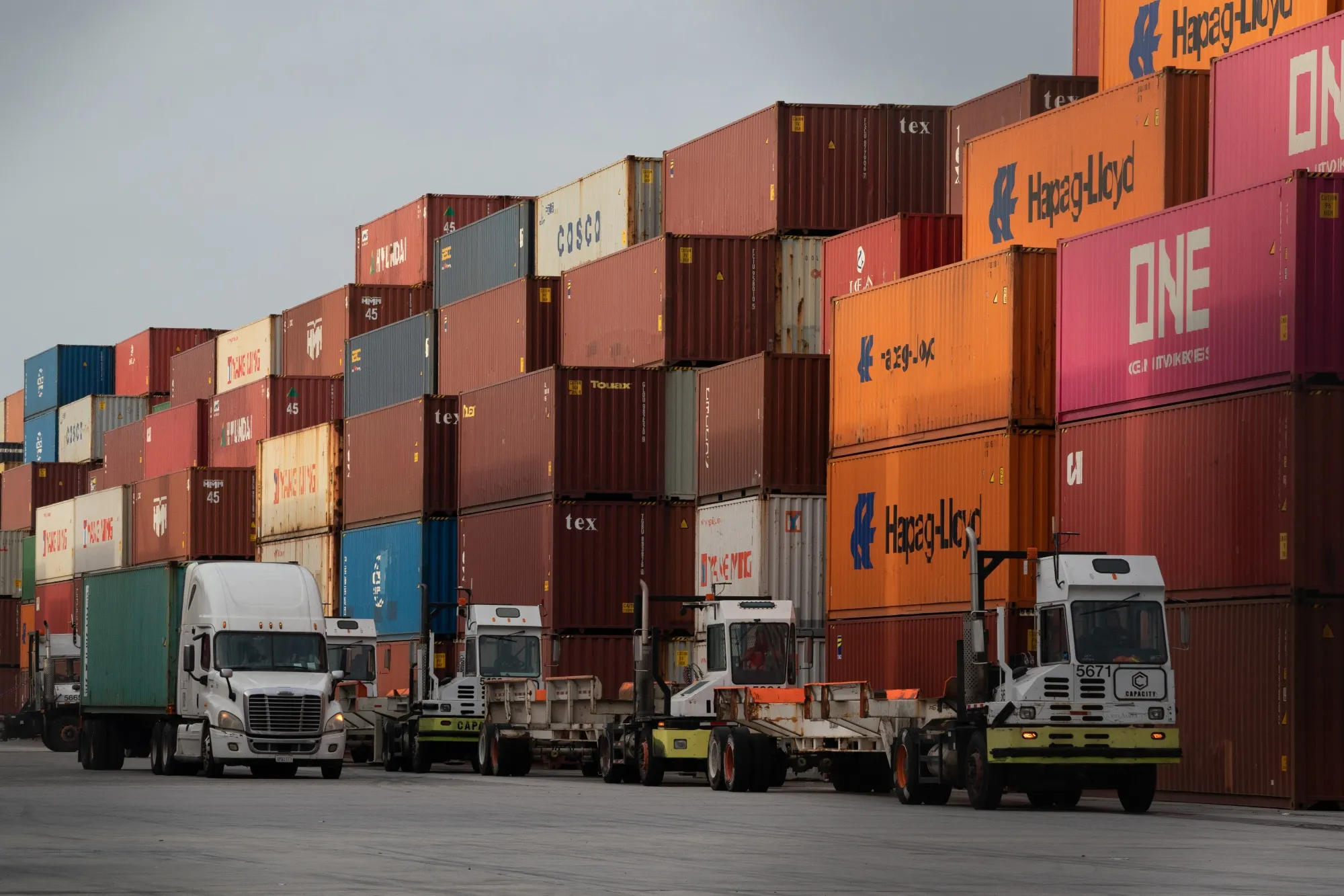 Trucks&nbsp;wait to be loaded with shipping containers at the Port of Los Angeles on Friday.