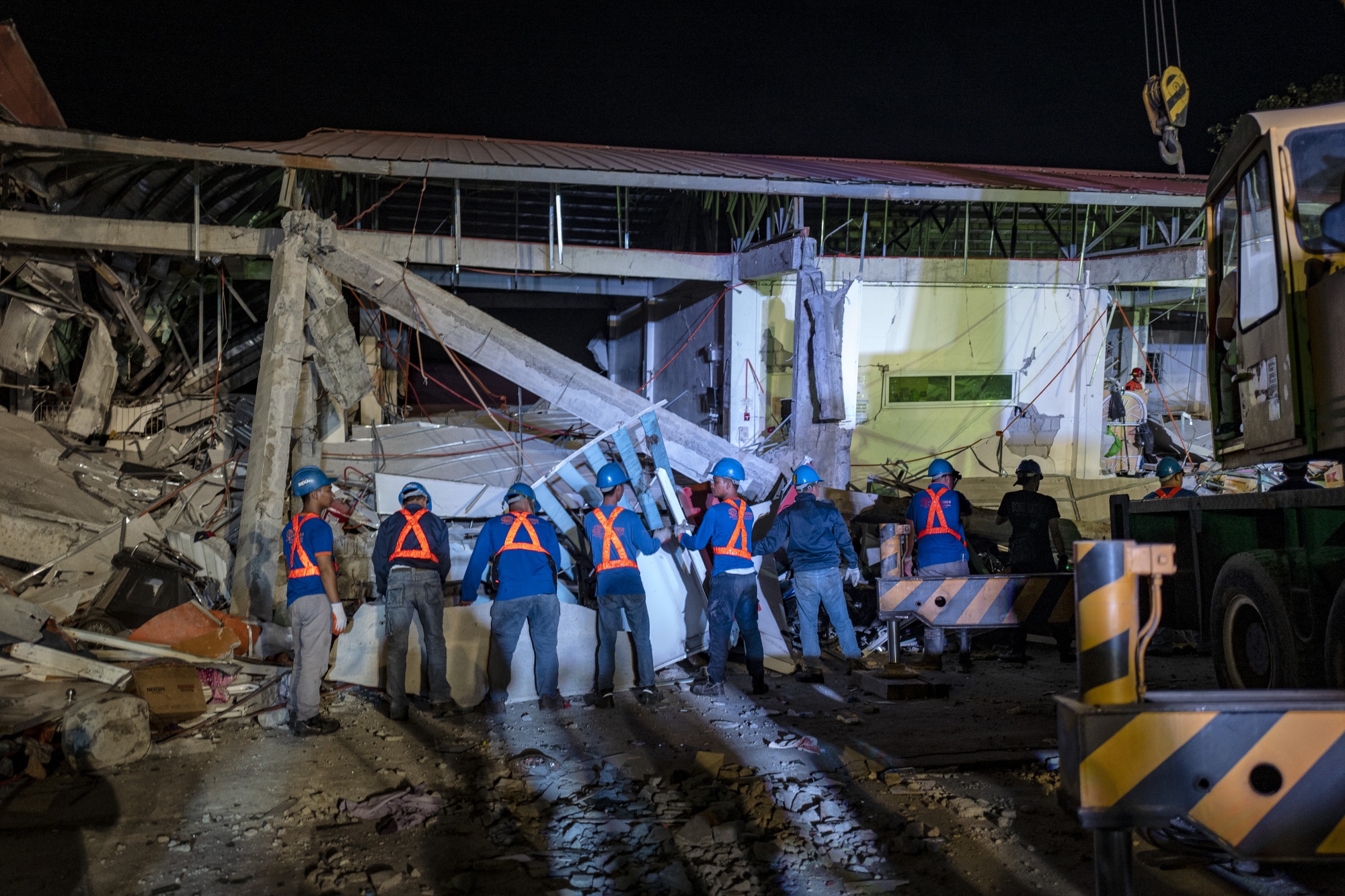 Rescuers search for survivors trapped in the debris of a collapsed building in Pampanga province, on April 23.