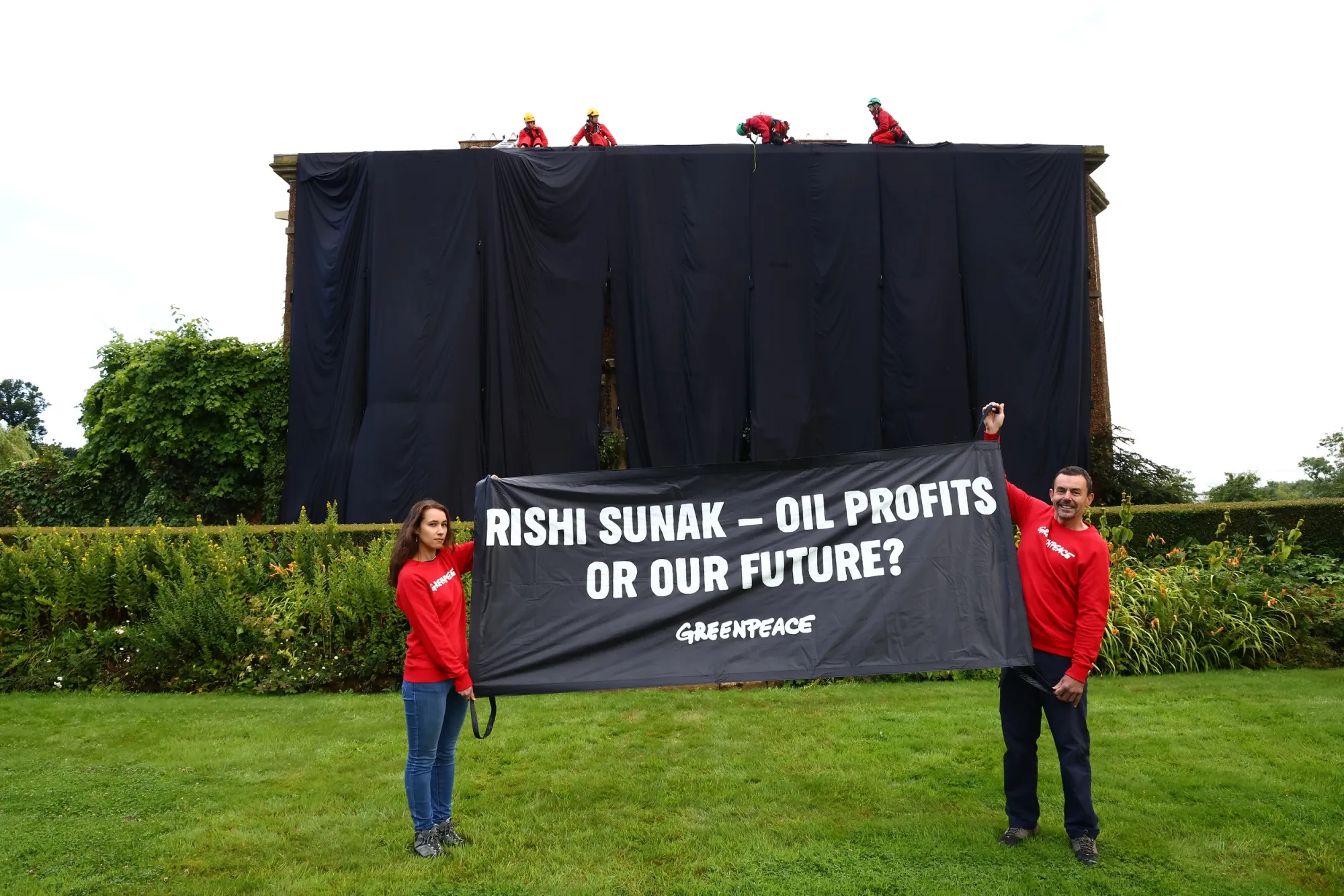 Greenpeace activists drape Rishi Sunak's property in black fabric, in Richmond, UK, on Aug. 3.