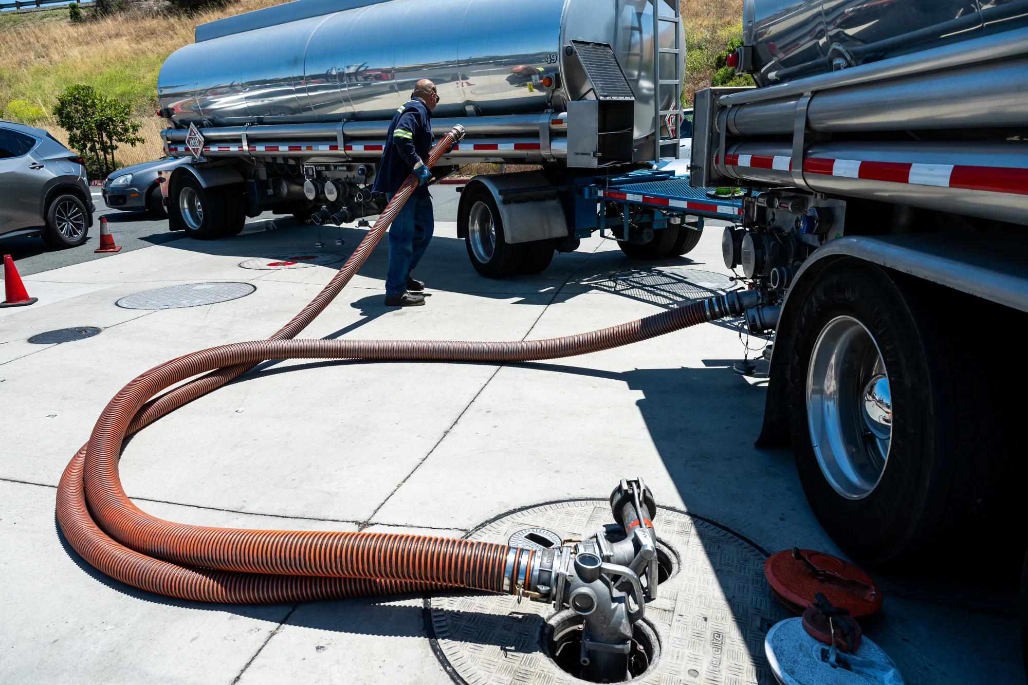 A worker prepares a fuel refill hose at a gas station in Hercules, California, on June 30.