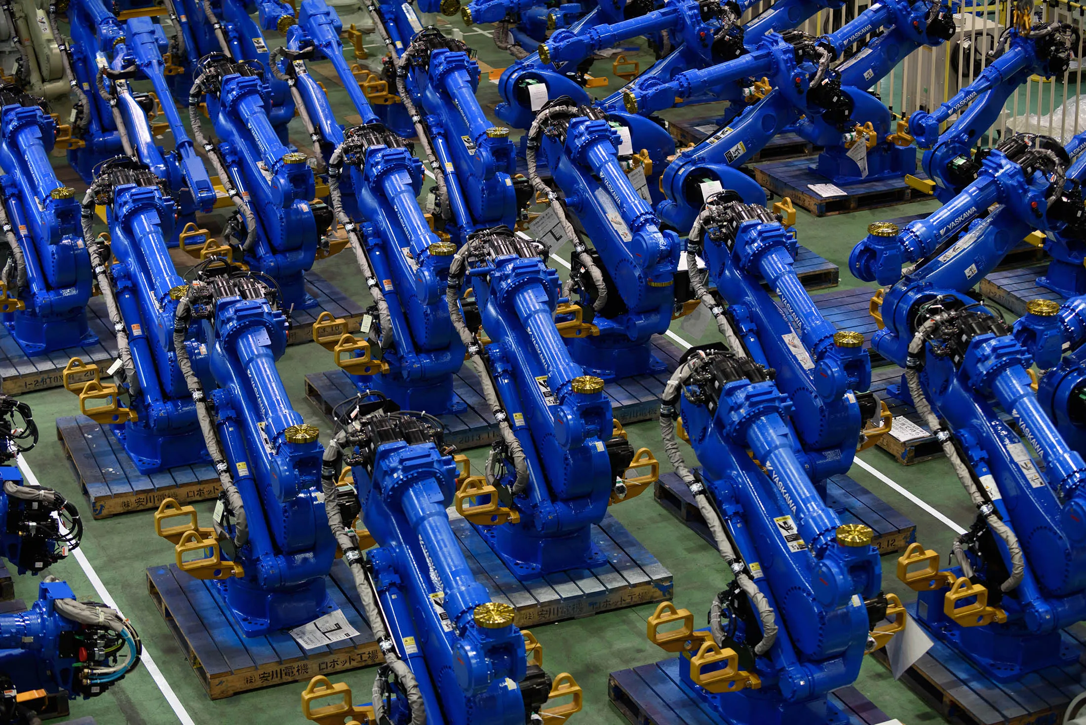 Yaskawa Electric Corp. Motoman robots bound for shipment sit at the company's factory in Kitakyushu, Japan, on Thursday, July 16, 2015. In factory robots, Japanese companies including Yaskawa Electric, Fanuc and Kawasaki Heavy Industries command 50 percent of the global market, according to the Ministry of Economy, Trade and Industry (METI).

