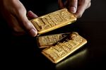 An employee handles one kilogram gold bullions at the YLG Bullion International Co. . 