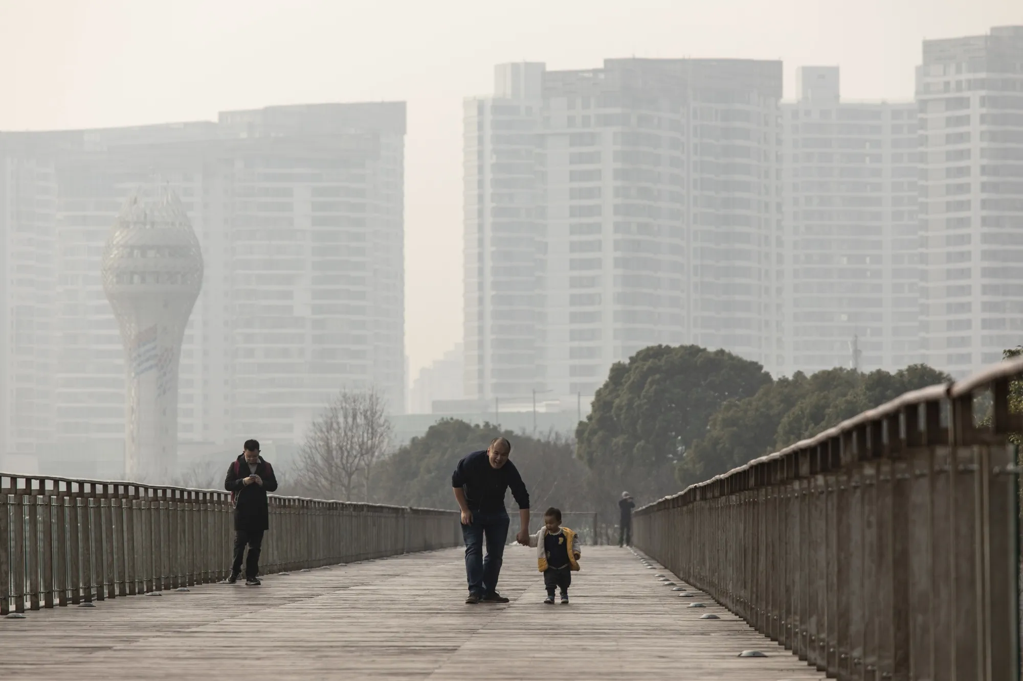 A family takes a stroll down a riverside boardwalk in Shanghai.