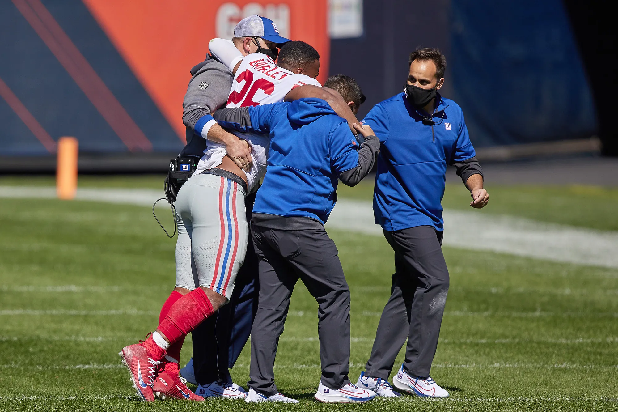 Saquon Barkley is assisted off the field by New York Giants medical staff and trainers during a game in Chicago on Sept. 20.