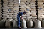 A worker stacks bags of unroasted robusta coffee beans in the warehouse at Banaran Coffee Plantation in Bawen, Semarang regency, in Central Java, Indonesia.
