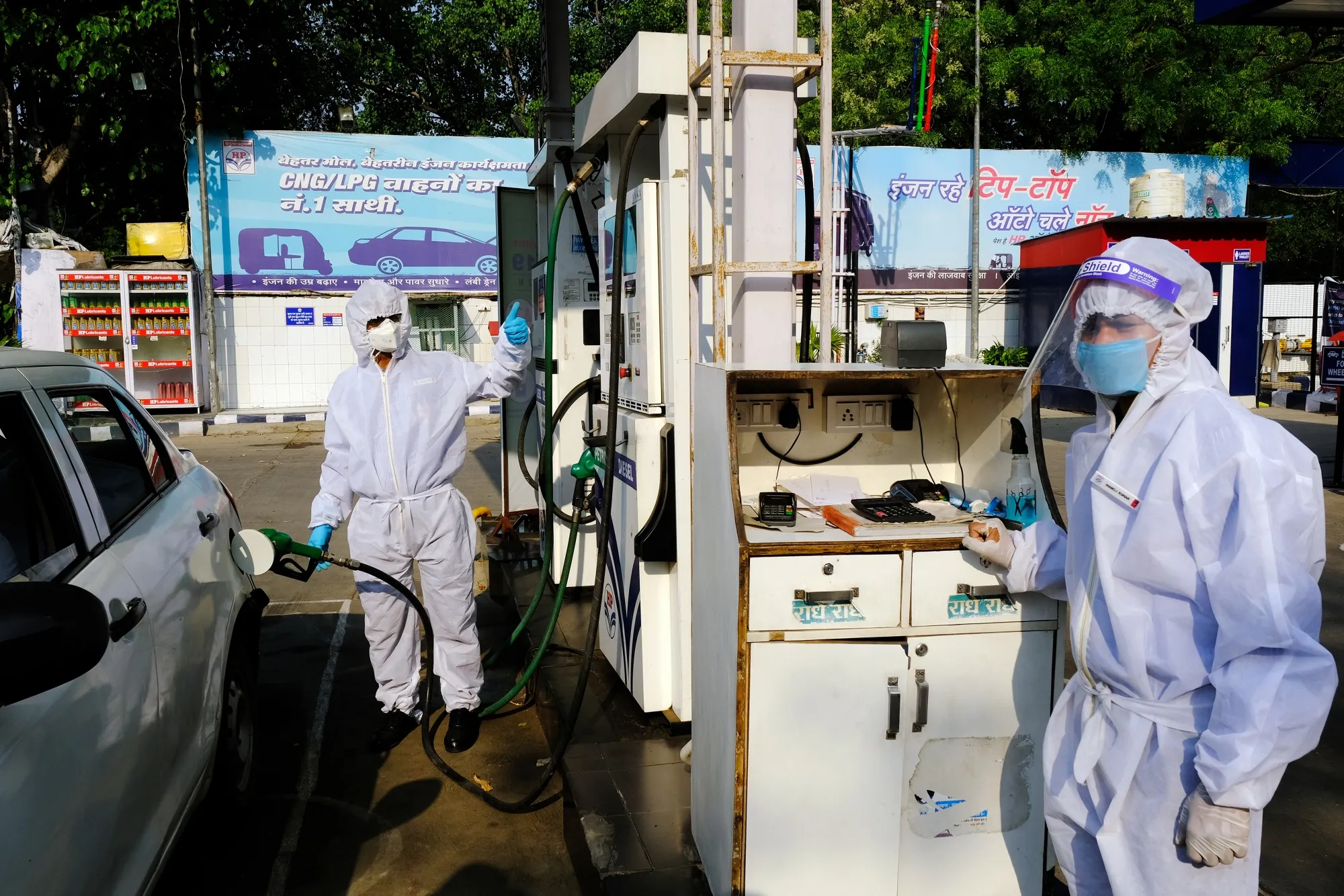 Employees wearing PPE&nbsp;refuel a vehicle at a&nbsp;gas station in New Delhi, India, on&nbsp;April 27.&nbsp;
