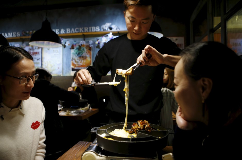 Diners in Seoul prepare to eat pork with cheese.