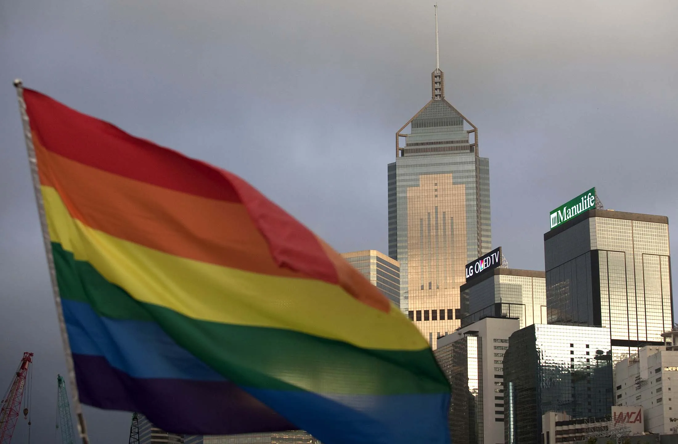 A rainbow flag is seen in front of the city skyline in Hong Kong.
