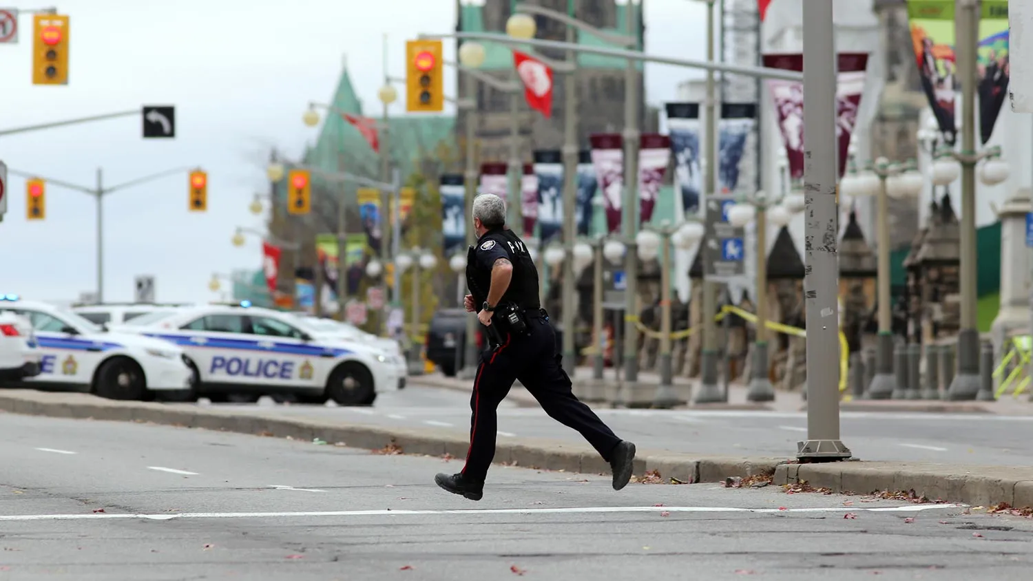 An Ottawa police officer runs across Wellington St. near the National War Memorial where a soldier was shot earlier in the day, just blocks away from Parliament Hill, on October 22, 2014 in Ottawa, Canada.
