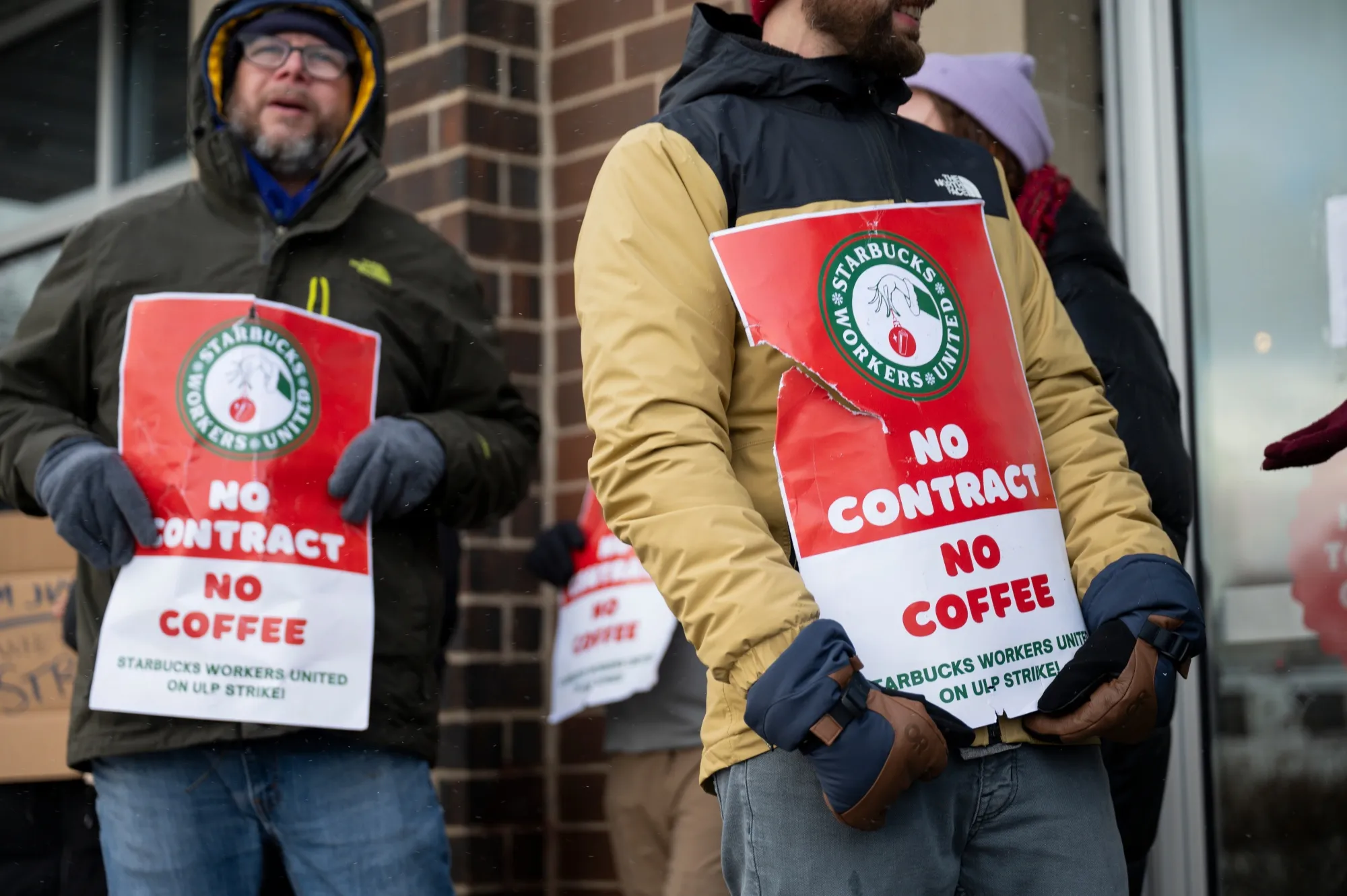 Starbucks Workers United members hold signs while picketing outside a Starbucks store in Chicago on Dec. 20.&nbsp;