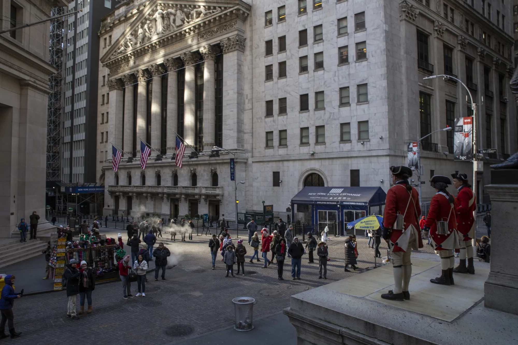 Pedestrians pass in front of the New York Stock Exchange (NYSE) in New York, U.S.