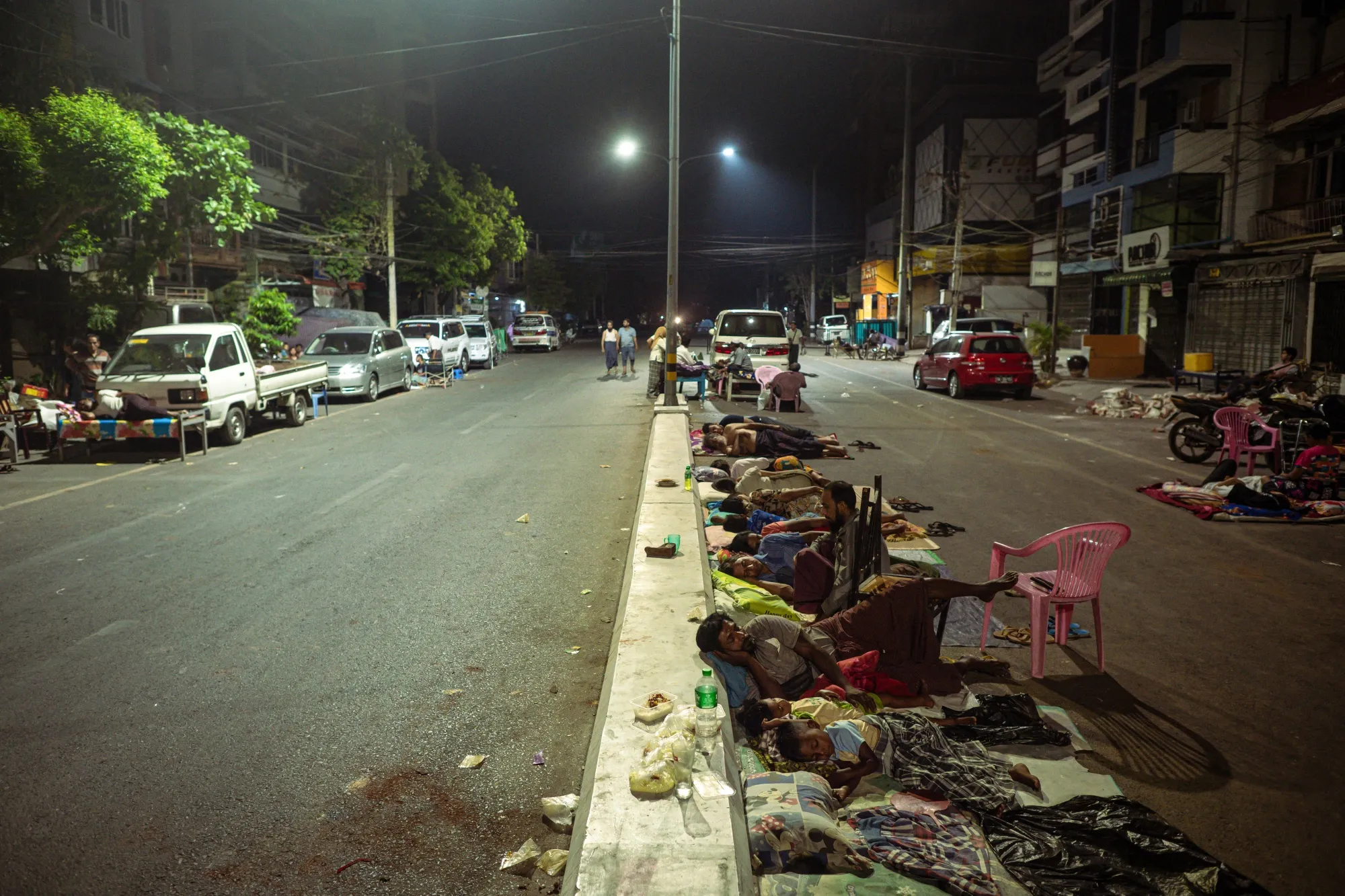 People sleep on the street in Mandalay on March 31.
