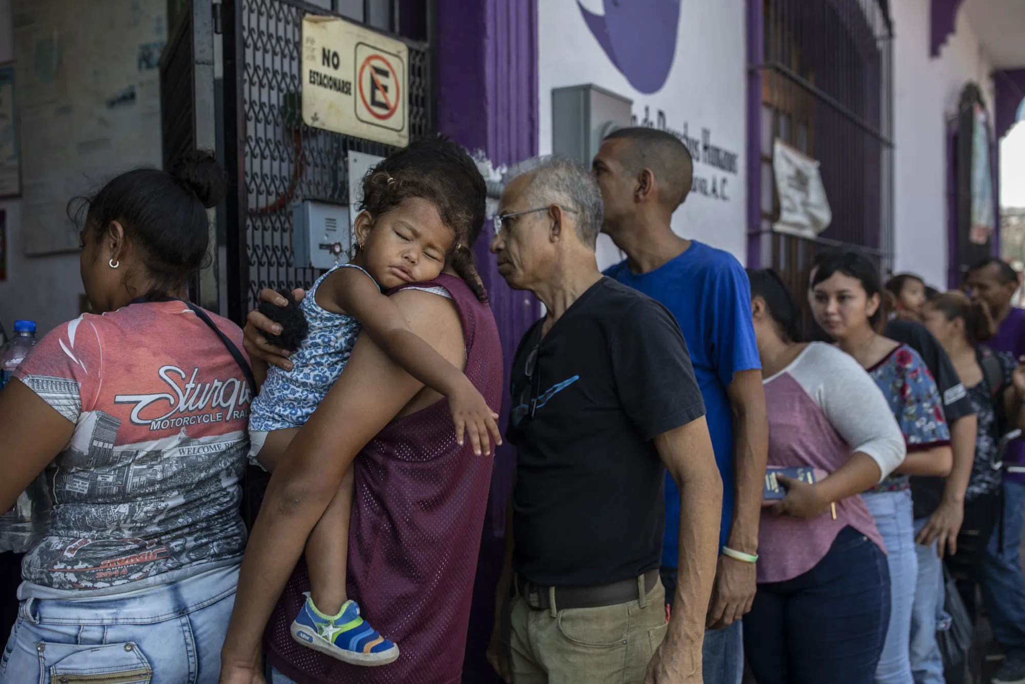 Migrants stand in line to enter a human rights center in Mexico.