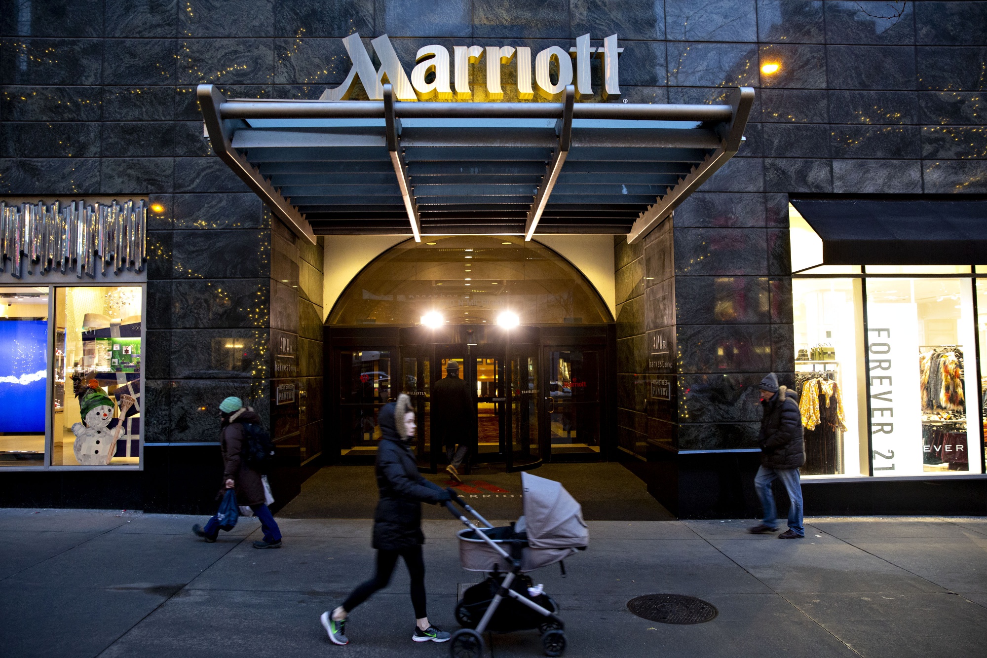 Pedestrians walk past a Marriott International Inc. hotel in Chicago, Illinois.