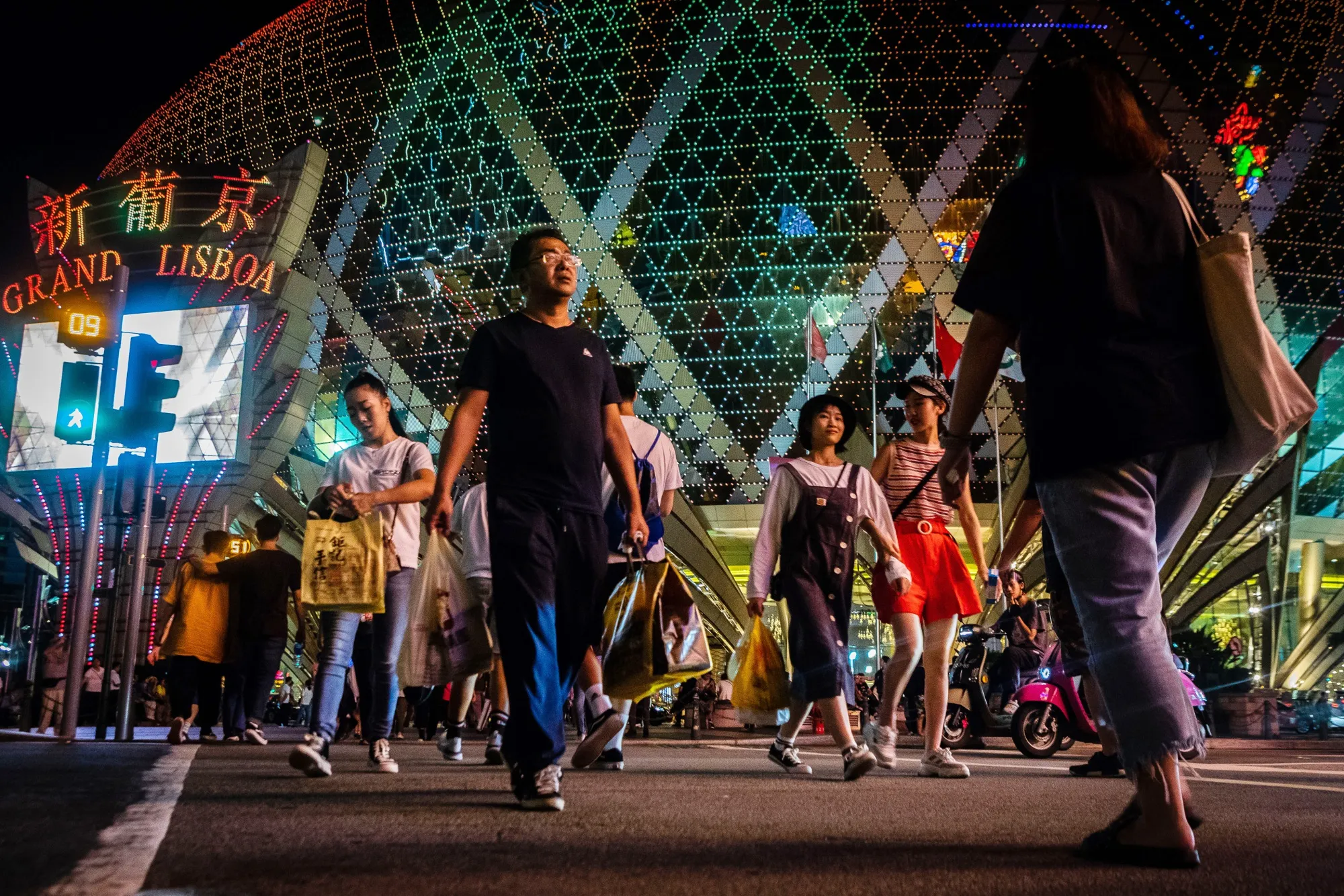 Pedestrians cross a road in front of Casino Grand Lisboa&nbsp;in Macau.
