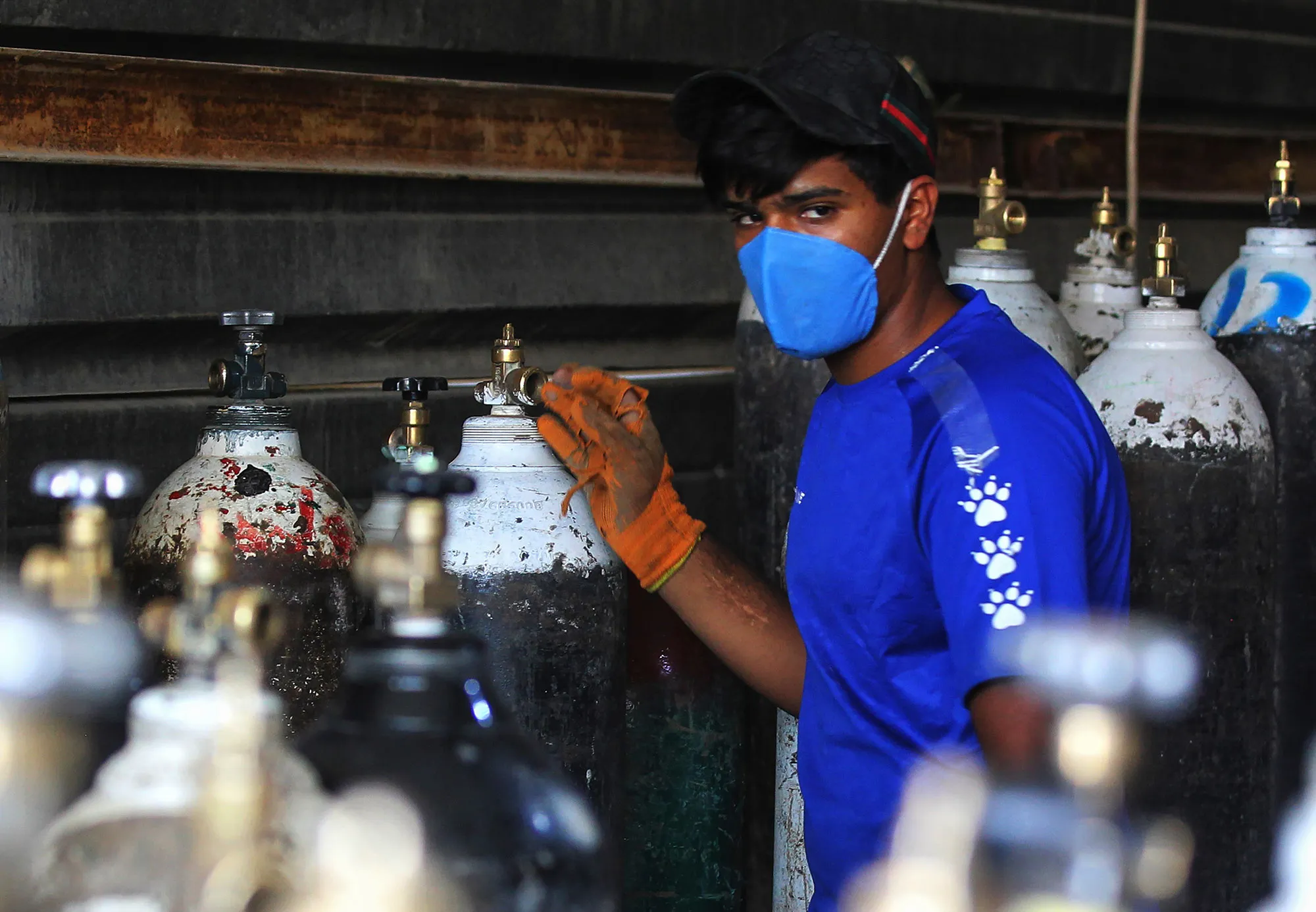 A worker refills oxygen cylinders at a factory in Baghdad, before delivering them to hospitals amid the COVID-19 pandemic.