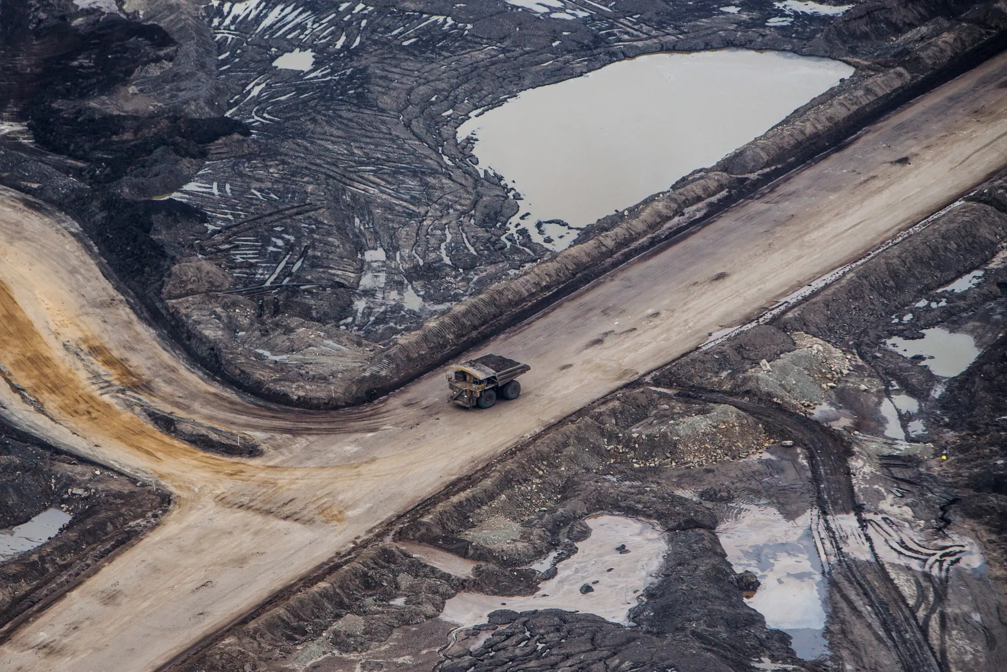A heavy hauler truck drives through the Suncor Energy Inc. Millennium mine in this aerial photograph taken above the Athabasca oil sands in 2018.