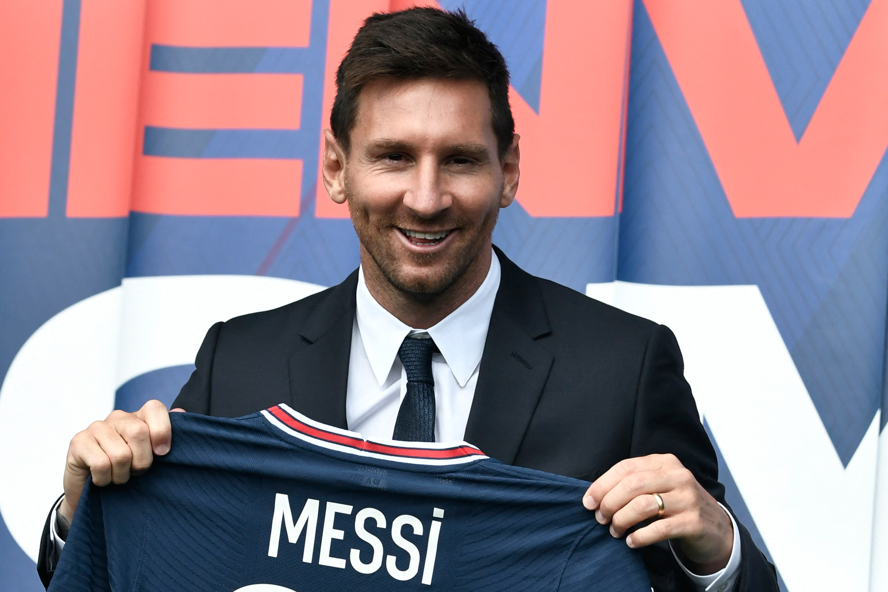 Lionel Messi holds his new Paris Saint-Germain jersey.