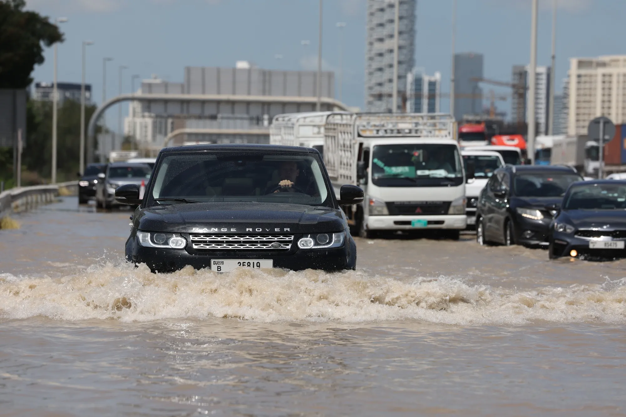 Drivers attempt to move their vehicles along a flooded highway after a rainstorm in Dubai.