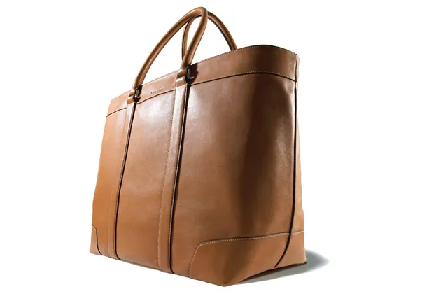 The understated Coach Bleecker Legacy Weekend Tote, made from cowhide, is available in five colors, including gray, red, and mahogany