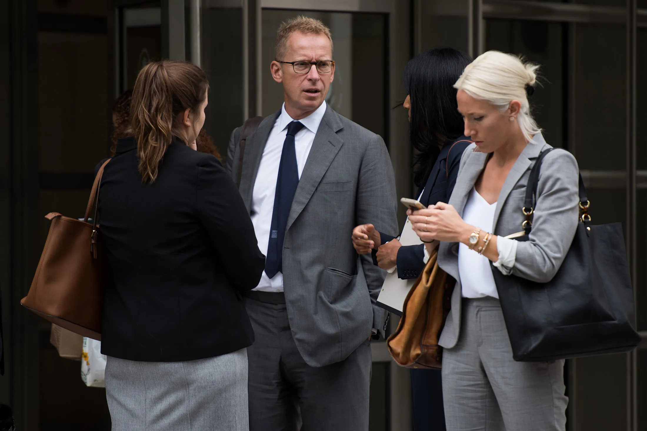 Mark Johnson, center, exits federal court in the Brooklyn borough of New York, on Sept. 18, 2017.
