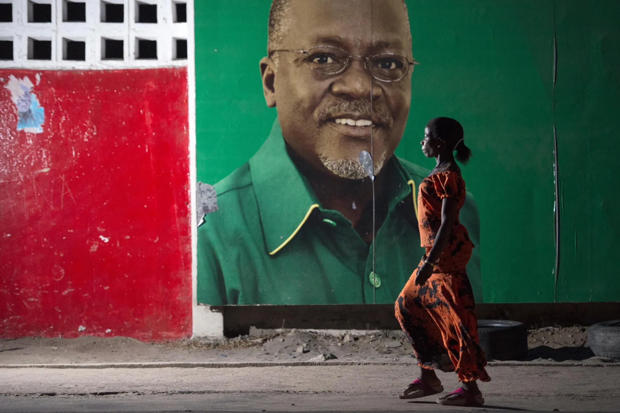 A woman walks past a billboard featuring John Magufuli in&nbsp;Dar Es Salaam, Tanzania.