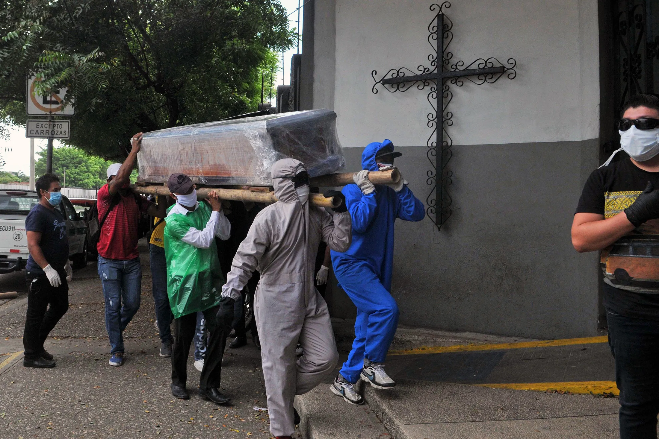 Relatives of a person who died from the new coronavirus carry the wrapped coffin to a cemetery in Guayaquil, Ecuador on April 17.