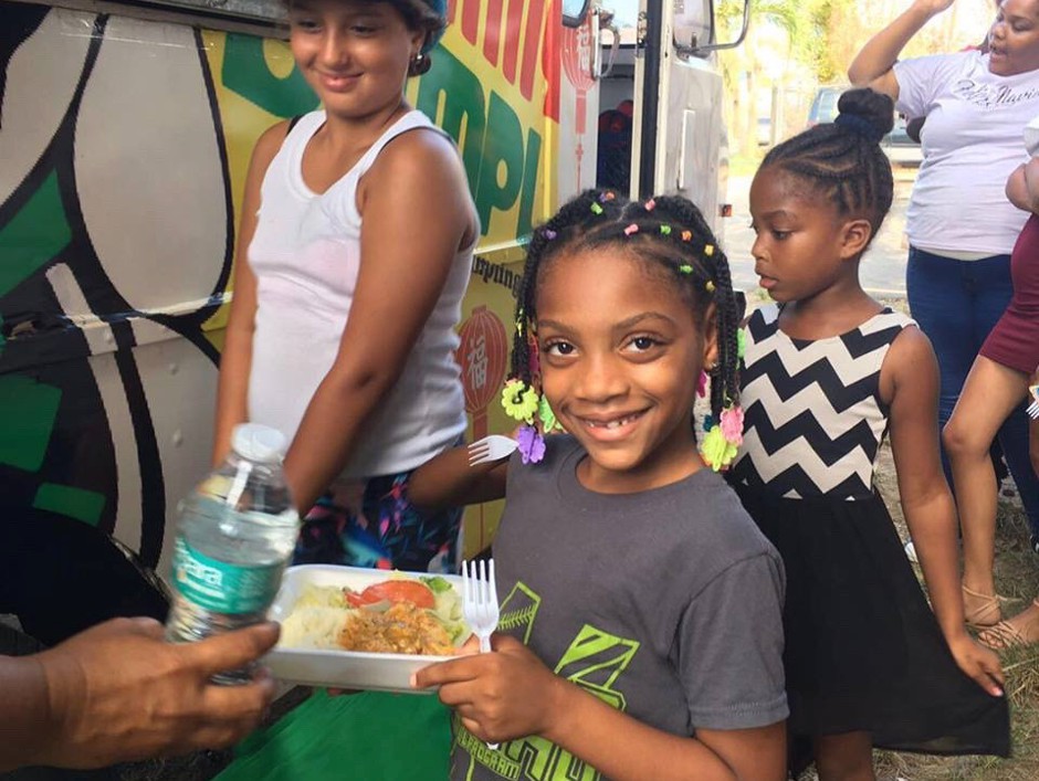 Children receive freshly cooked meals from World Central Kitchen.