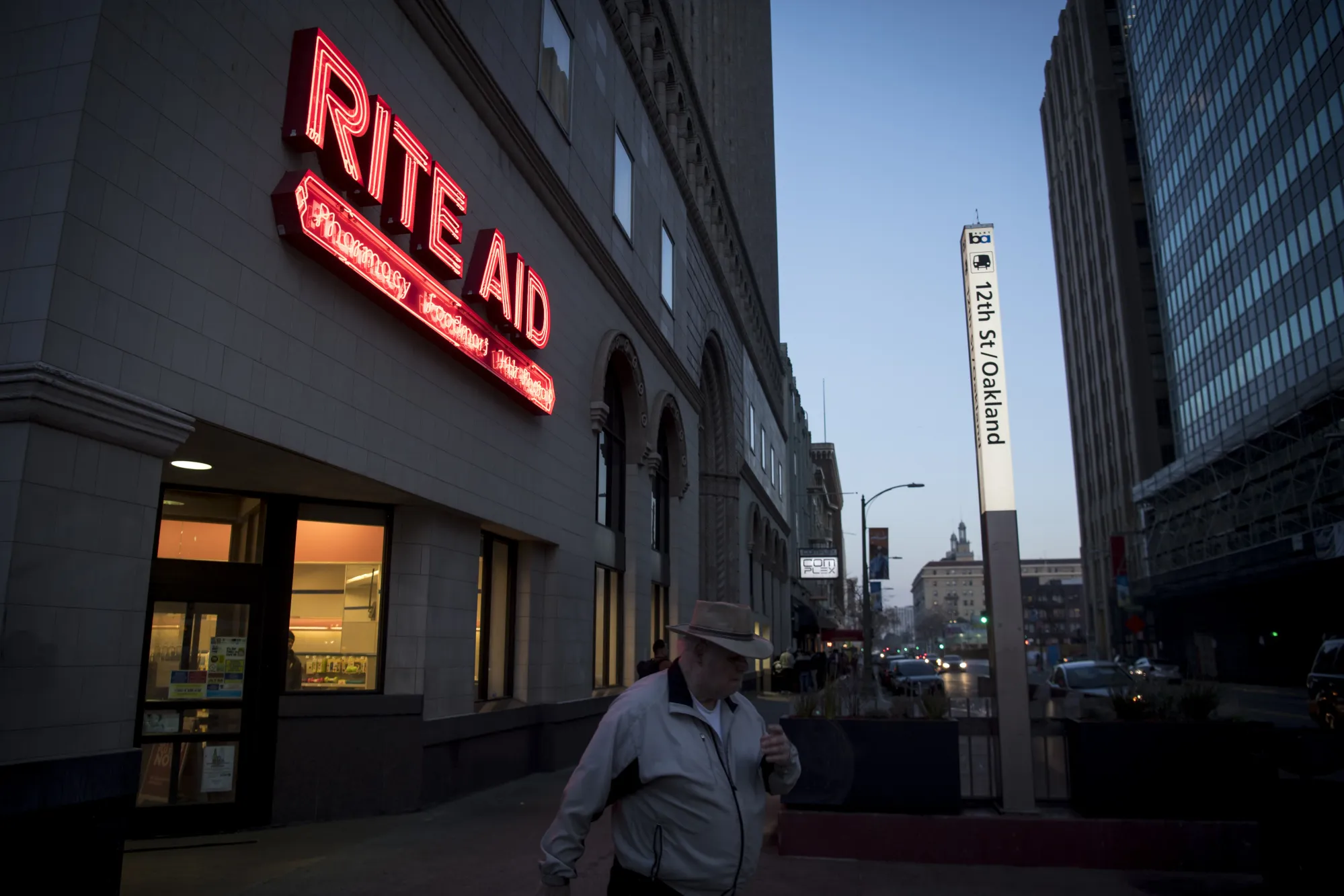 A pedestrian passes in front of a Rite Aid Corp. store in Oakland, California, U.S.