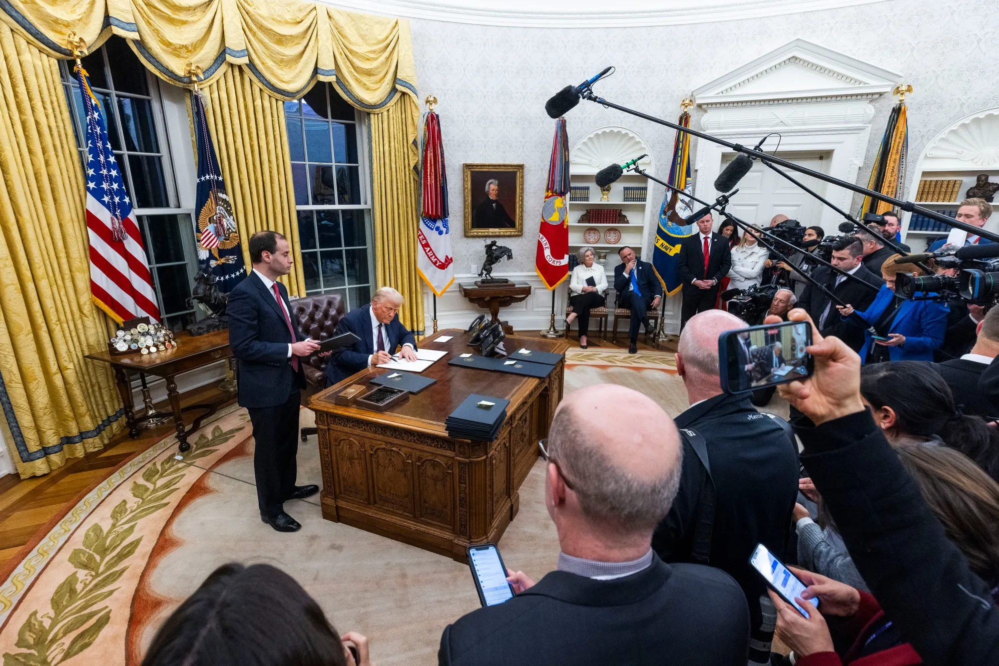US President Donald Trump signs an executive order in the Oval Office of the White House in Washington, DC, US, on Monday.