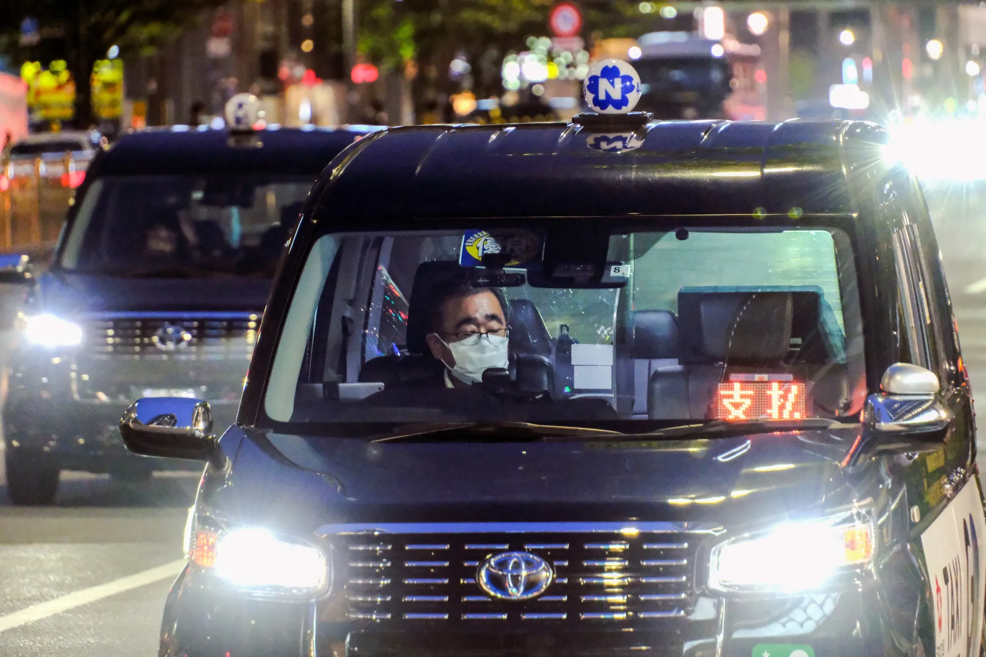 A taxi driver waiting for customers in front of Tokyo Station.