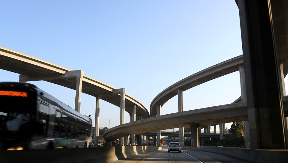 A transit bus makes its way under a freeway in Los Angeles, California.