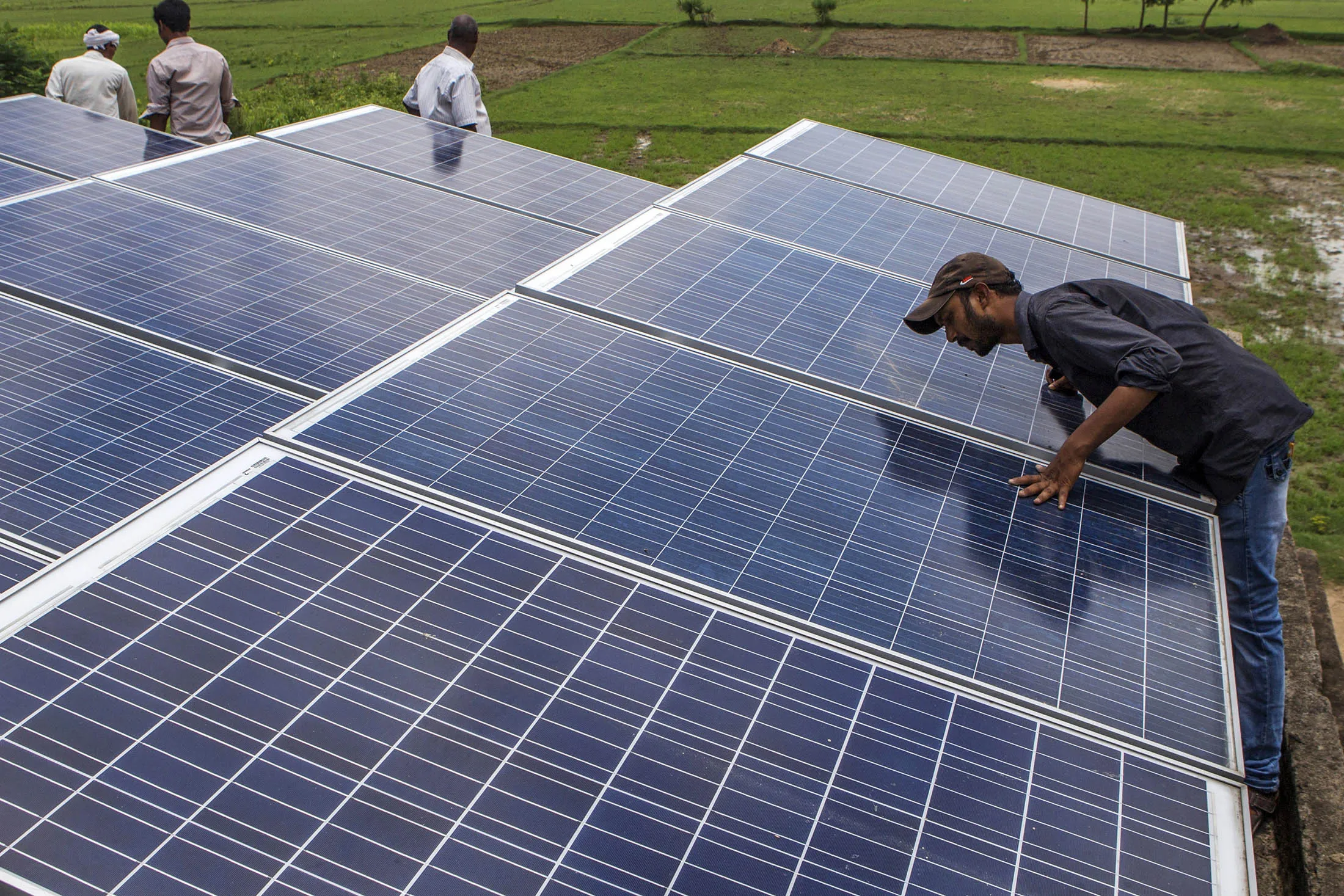 An employee inspects solar panels, part of a solar power microgrid, in the village of Dharnai in Jehanabad, Bihar, India, on Thursday, July 9, 2015. While Prime Minister Narendra Modi's ambition has led billionaires such as Foxconn Technology Group's Terry Gou to pledge investment, the question remains whether the 750 million Indians living on less than $2 per day can afford or will embrace green energy.
