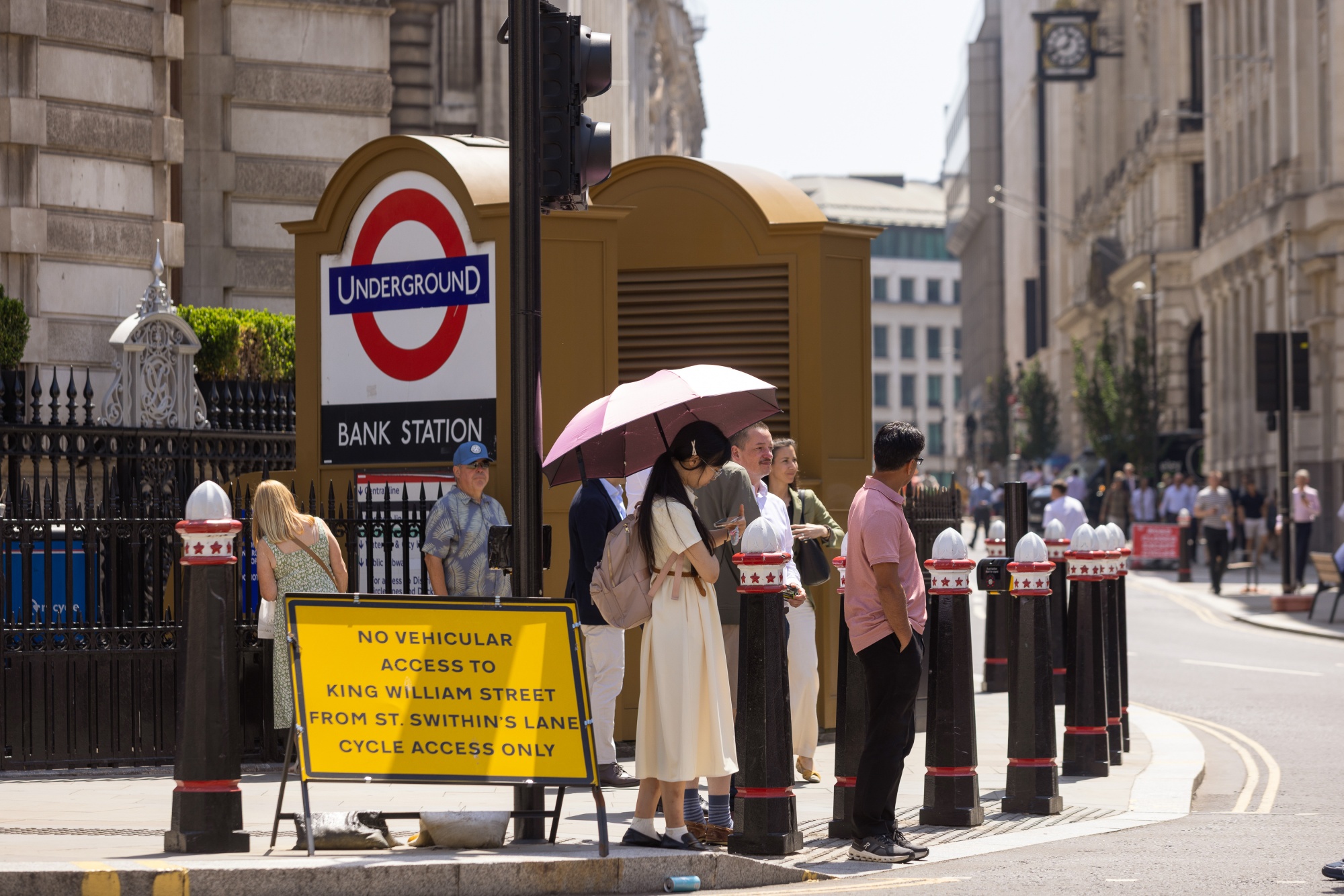A pedestrian uses an umbrella as protection from the sun during a heat wave in the City of London, UK, on Thursday, June 25, 2026. The heat wave baking western Europe smashed records in the UK and France, as the region faces another day of disruptive temperatures. Photographer: Betty Laura Zapata/Bloomberg