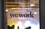 The WeWork logo sits on the exterior of a glass door at the co-working office space, operated by the parent company We Co., on Eastcheap in London, U.K.