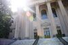 A masked student studies outside the closed Wilson Library on the campus of the University of North Carolina at Chapel Hill.