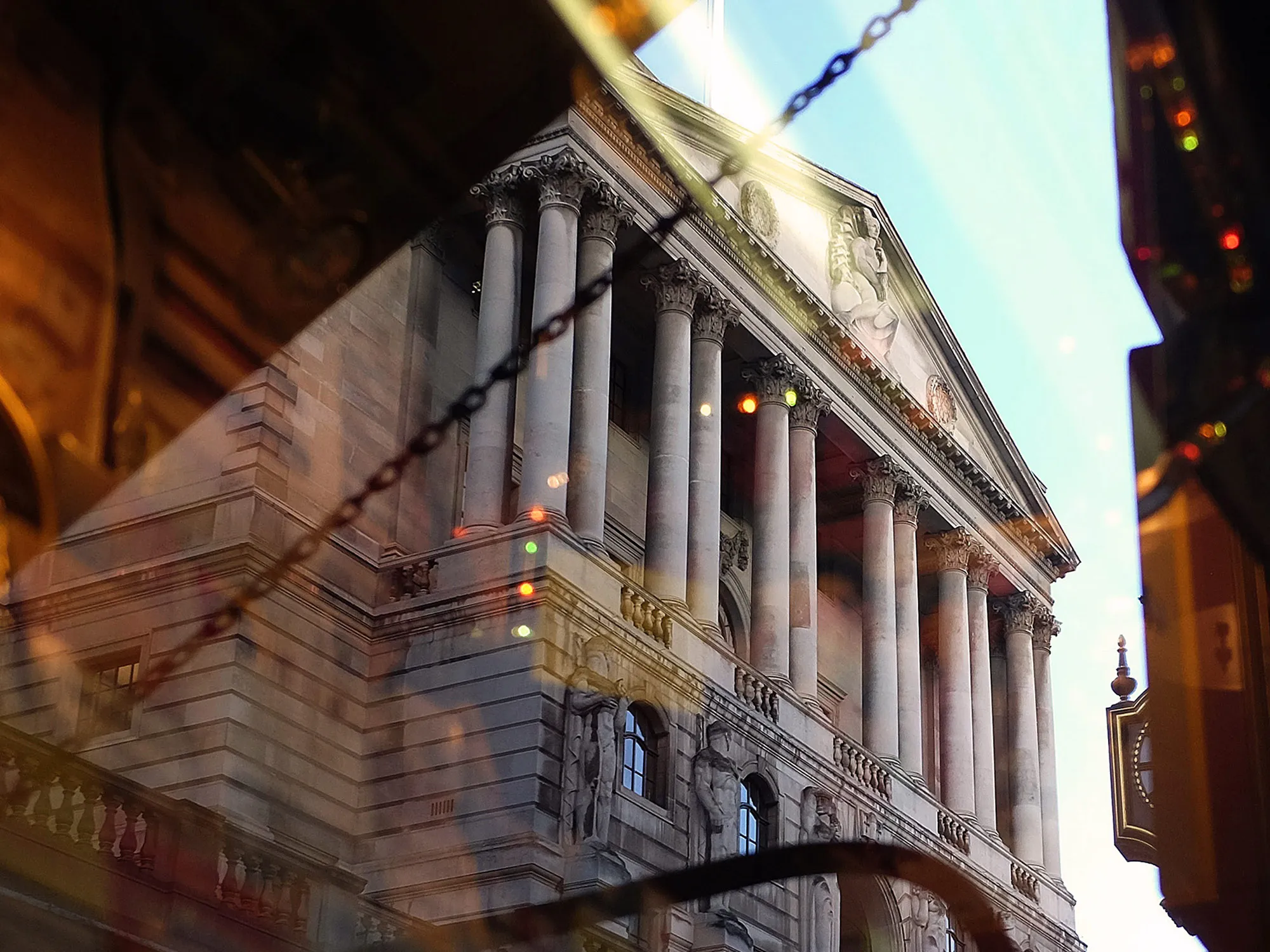 The Bank of England is reflected in the glass window of a retail store in London, U.K.