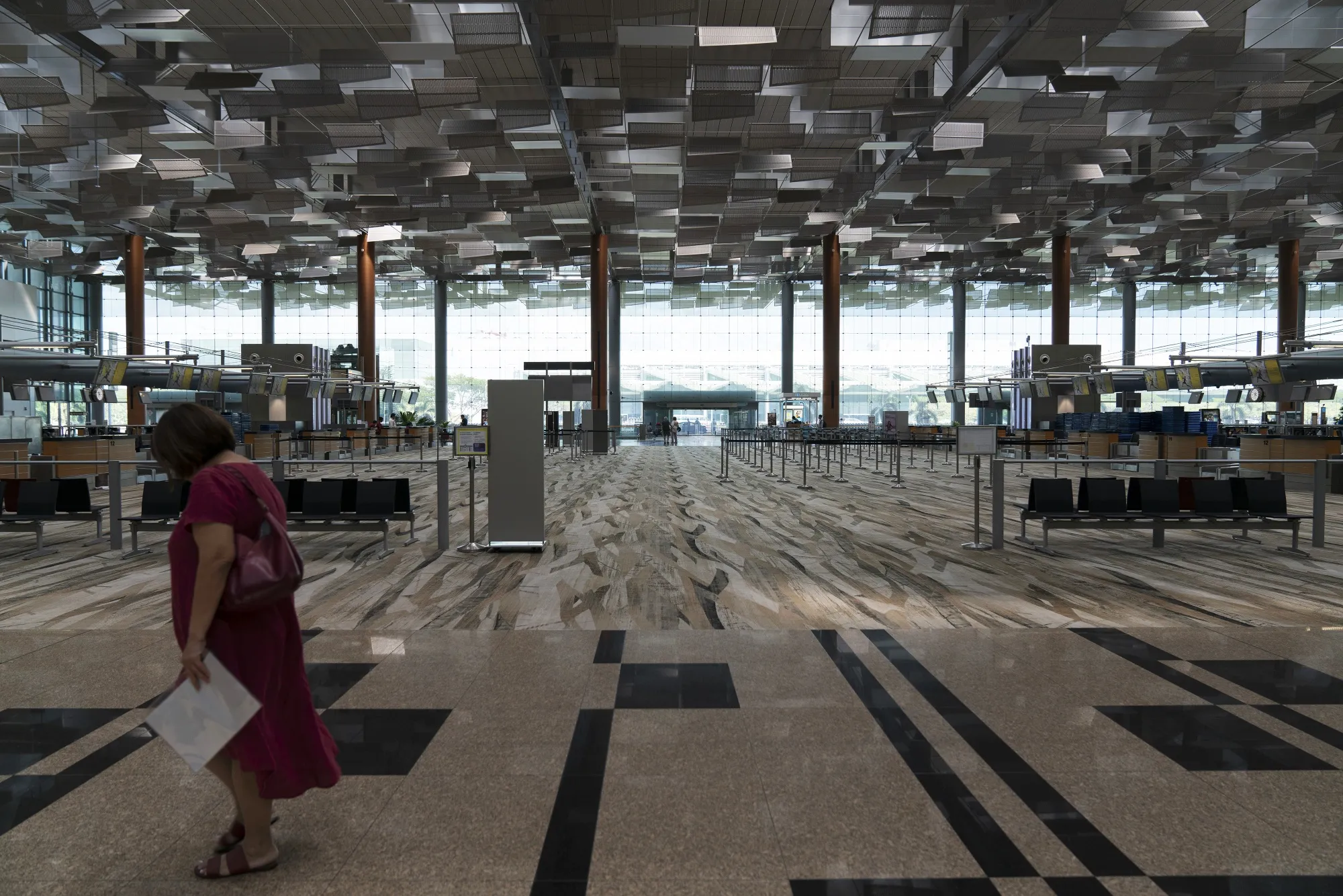 A woman walks past an empty check-in area in Terminal 3 at Singapore Changi Airport in Singapore,&nbsp;March 17.