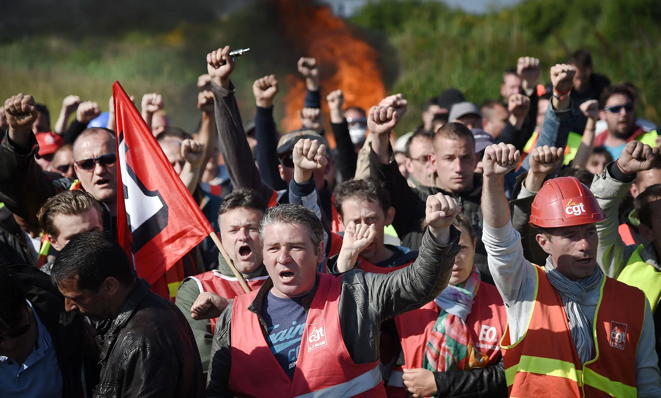 Workers on strike are evacuated by French riot policemen as they block the access to an oil depot near the Total refinery of Donges, western France, to protest against the government's planned labour law reforms, on May 27, 2016. The French government's labour market proposals, which are designed to make it easier for companies to hire and fire, have sparked a series of nationwide protests and strikes over the past three months. French unions on May 27 called on workers to 'continue and step up their action', as a wave of strikes against a disputed labour law disrupted transport and fuel supplies. / AFP / JEAN-SEBASTIEN EVRARD (Photo credit should read JEAN-SEBASTIEN EVRARD/AFP/Getty Images)
