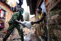 A military officer hands out food&nbsp;during the relief food distribution in Kampala, on April 4.&nbsp;