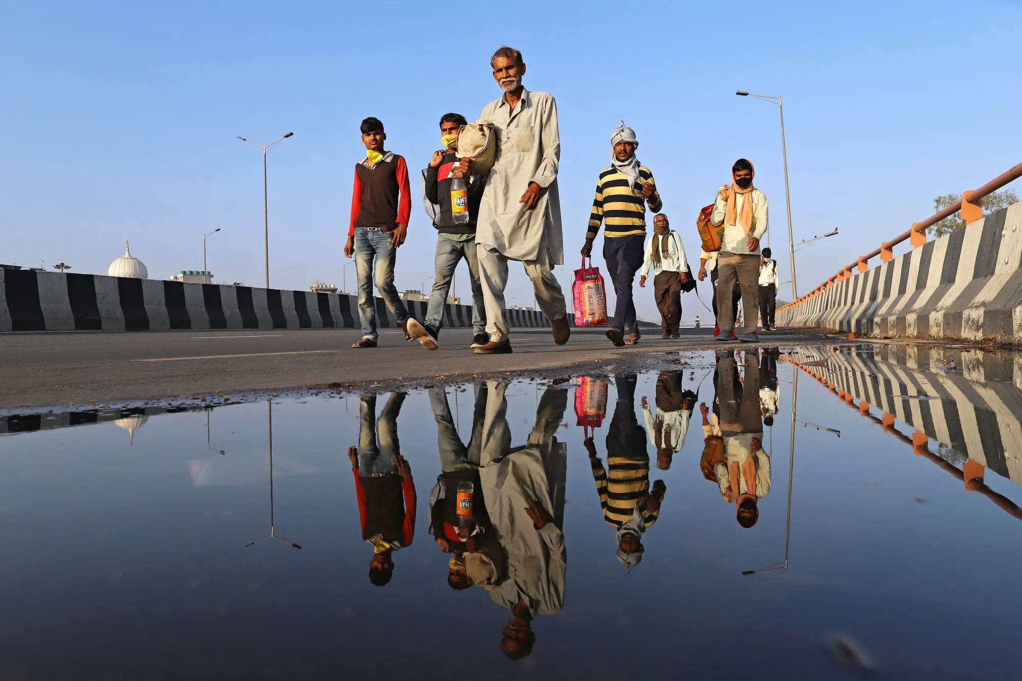 Migrant workers and their families walk along a road during a lockdown imposed due to the coronavirus in New Delhi, India, on&nbsp;March 28.