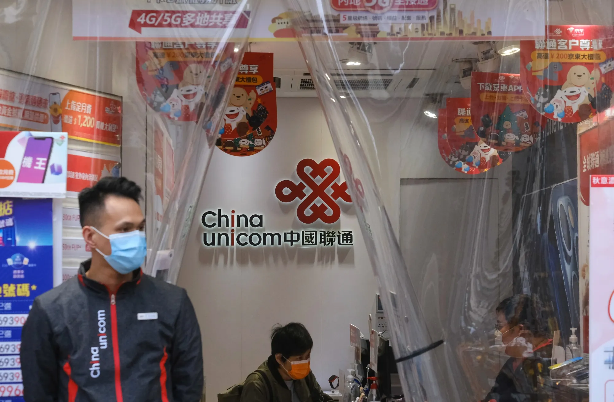 Sales assistants work at a China Unicom Hong Kong Ltd. store in Hong Kong.