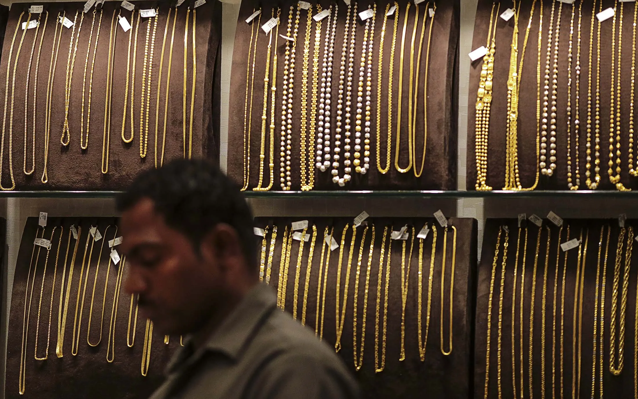 Gold chains and necklaces sit on display inside a store in the Zaveri Bazaar area of Mumbai, India.
