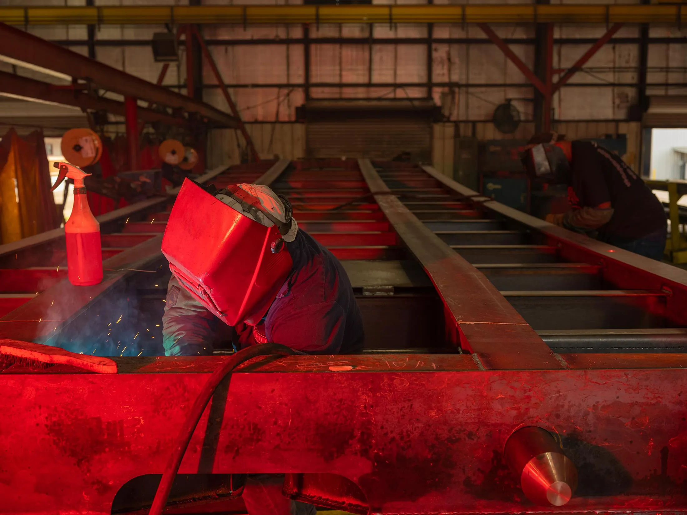 Welders at Pitts Enterprises in Pittsview, Alabama, work on a trailer chassis.