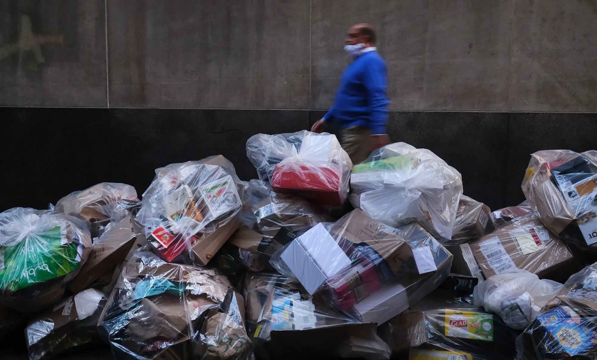 A person walks past garbage in the Financial District in Manhattan on Oct. 1.